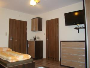 a bedroom with wooden furniture and a flat screen tv at Villa Piaski in Krynica Morska
