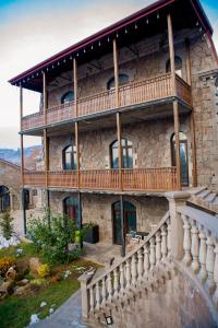 un gran edificio de piedra con un gran balcón en Khoreayi Dzor, en Goris