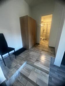 an empty room with a chair and a door at Milan Apartman in Budapest