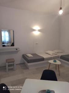 a bedroom with a bed and a mirror and a table at Vlastos 1 in Ios Chora