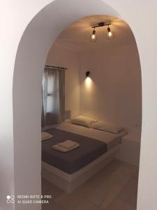 a bedroom with a bed under an archway at Vlastos 1 in Ios Chora +12 photos