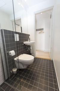 a bathroom with a toilet and a walk in shower at Keybutler Royal Park Studios in Oslo