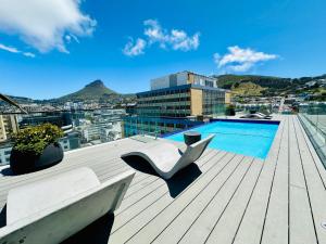 a deck with a chair and a swimming pool on a building at The Tokyo 708 - Family Studio in Cape Town