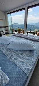 dwa łóżka w pokoju z dużym oknem w obiekcie Bem Vindo Ao Presente w mieście Igrejinha