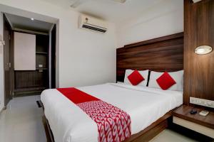 een slaapkamer met een groot wit bed met rode kussens bij Super OYO Flagship Hotel Everest Lodging Vashi in Mumbai