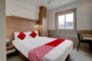 a bedroom with a bed and a desk and a window at Super OYO Flagship Hotel Everest Lodging Vashi in Mumbai
