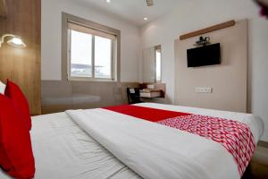 een slaapkamer met een groot bed en een rode deken bij Super OYO Flagship Hotel Everest Lodging Vashi in Mumbai