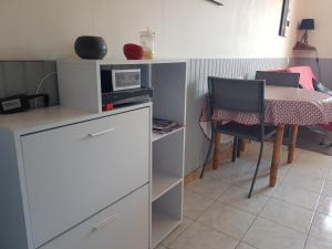- une cuisine avec une table, une table et des chaises dans l'établissement Studio Albizia Lamalou les Bains, à Lamalou-les-Bains
