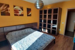 een slaapkamer met een bed en een gele muur bij Quiet Mountain Home, Free Parking & View in Sofia