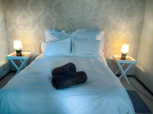 a white bed with two towels on it with two lamps at Mitchell Guesthouse in Pietermaritzburg +5 photos