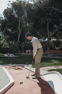 a man standing on a sidewalk with a stick at Hotel Xaloc Playa in Punta Prima