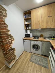 a kitchen with a washer and a brick wall at Apartments by PA in Lviv