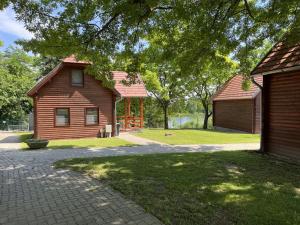 uma casa e um celeiro ao lado de um edifício em Termálfalu és Kemping Zalaegerszeg - Standard Plus em Zalaegerszeg