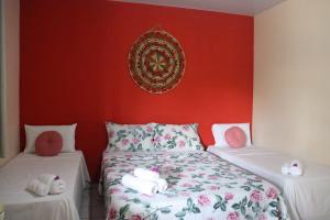 um quarto com uma cama e uma parede vermelha em Pousada Boa Vista em Barreirinhas