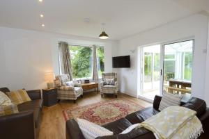 a living room with a couch and chairs and a tv at Whisperwood at Carrick Castle Estate in Carrick