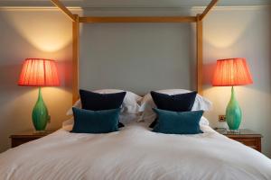 a bedroom with a large bed with two lamps at East Beach Guest House in Littlehampton