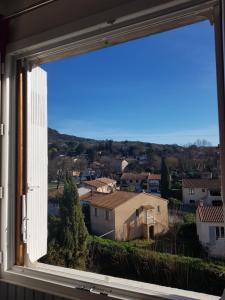 une fenêtre avec vue sur la ville dans l'établissement Studio Albizia Lamalou les Bains, à Lamalou-les-Bains