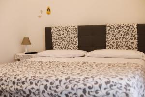 1 dormitorio con 1 cama con edredón blanco y negro en B&B LIOLA', en Patti