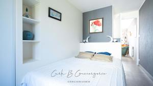 EVASION MARINE appartement VUE MER 2-4 personnes في كونكارنو: غرفة نوم بها سرير أبيض في الغرفة