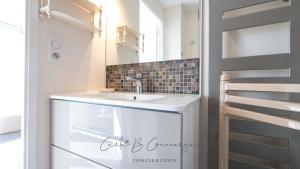 EVASION MARINE appartement VUE MER 2-4 personnes في كونكارنو: حمام مزود بحوض ومِرآة +13 صورة