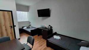 a living room with a couch and a tv on the wall at Baza noclegowa Mistral in Sieradz