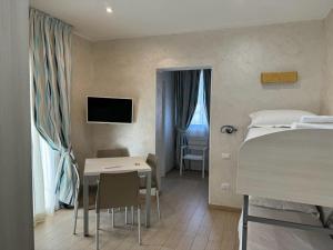 Schlafzimmer mit einem Bett, einem Schreibtisch und einem Tisch in der Unterkunft Marina Beach Aparthotel in Rimini