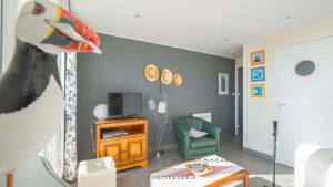 EVASION MARINE appartement VUE MER 2-4 personnes في كونكارنو: غرفة معيشة بها غرفة بها حيوان محشو