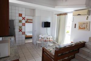sala de estar con mesa y dormitorio en Tarot Residence, en Florianópolis