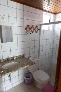 a bathroom with a toilet and a sink and a mirror at Tarot Residence in Florianópolis