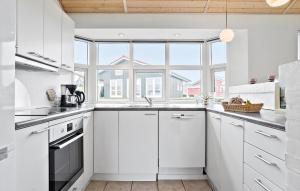 una cucina con mobili bianchi e una grande finestra di Holiday Home Vinkelbæk Nordborg Denm a Nordborg