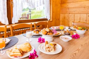 - une table avec des assiettes de nourriture et de boissons dans l'établissement Hotel Gruppo Brenta, à Andalo