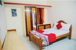 een slaapkamer met een bed met een rode deken bij Garuda Grand in Tirupati