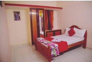 een kleine slaapkamer met een bed en een spiegel bij Garuda Grand in Tirupati