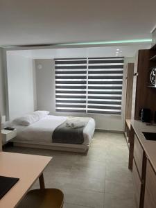 a bedroom with a bed and a large window at Live Epicentro in Temuco