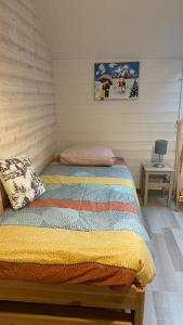 een slaapkamer met een bed met een gestreept dekbed bij Gîte de la Mésange in Rochesson