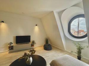 a living room with a tv and a round window at Ultracentral modern city view apartment in Târgu-Mureş
