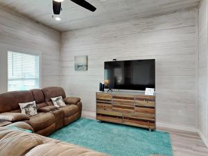 a living room with a couch and a flat screen tv at Oasis On The Bay in Rockport