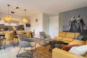 een woonkamer met een gele bank en stoelen bij Hello Zeeland - Vakantiewoning Knuitershoek 88 