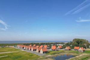 een luchtzicht op een rij huizen met oranje daken bij Hello Zeeland - Vakantiewoning Knuitershoek 88 