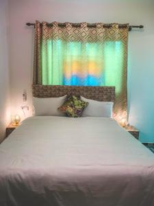 um quarto com uma grande cama branca e uma janela em Riad dar Yamna em Fez