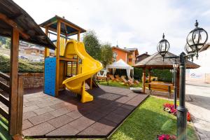une aire de jeux avec toboggan jaune et toboggan dans l'établissement Hotel Gruppo Brenta, à Andalo
