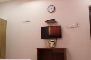 a room with a tv and a clock on the wall at CHENNAI PALACE in Chennai