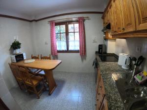 małą kuchnię z drewnianym stołem i oknem w obiekcie Twin Room at Villa Lila w Puerto de la Cruz