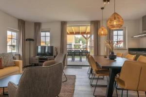 a living room with a table and a dining room at Hello Zeeland - Vakantiewoning Knuitershoek 64 