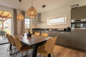 a kitchen with a dining room table and chairs at Hello Zeeland - Vakantiewoning Knuitershoek 64 