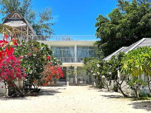 ギリ島にあるSeri Resort Gili Meno - Adults Onlyの目の前に木々と花々が咲き誇る建物