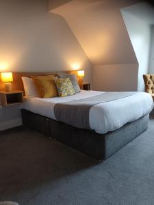 a large bed in a room with two lamps at Castle Lodge Kilkenny in Kilkenny