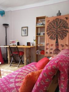 a bedroom with a bed with a tree tapestry on the wall at Casita natural y encantadora en El Bierzo in Congosto