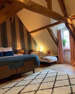 a attic bedroom with two beds and a window at Hamiora wellness B&B in Deinze