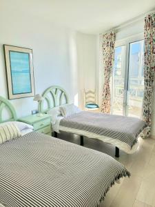 a bedroom with two beds and a balcony at SEA VIEW & BEACH ACCESS - Center - Parking in Marbella